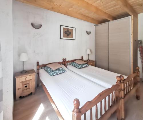 a bedroom with a large white bed with two pillows at Maison chaleureuse à Courchevel avec vue sur montagnes in Courchevel