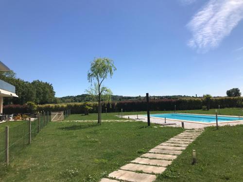 a swimming pool with a palm tree next to a yard at Agriturismo Villa Gaia in Lonato del Garda