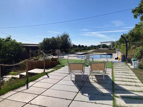 two chairs sitting on a patio next to a pool at Casa Vacanze immersa tra le colline, appartamento, vicinissima al mare e con nuova piscina in Senigallia