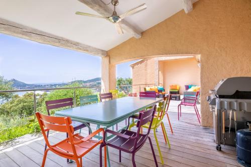 une salle à manger avec une table et des chaises sur une terrasse dans l'établissement Villa Mas d'Esterel - vue mer, à Saint-Raphaël