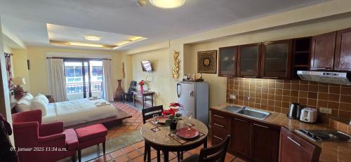 a kitchen and living room with a bed and a table at Nirvana Boutique Suites in Jomtien Beach