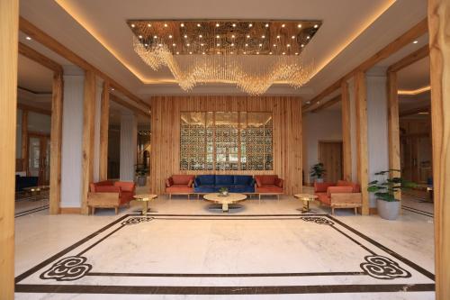 a lobby with a chandelier and a large rug at Hotel Rewa Ladakh in Leh