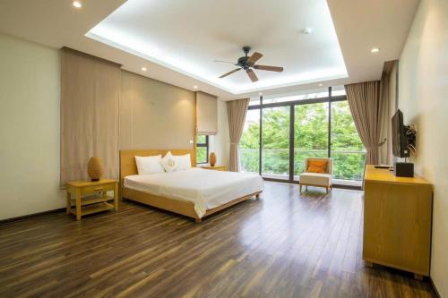 una camera da letto con un letto e un ventilatore a soffitto di Villa Sao Biển 38, SB38, Hồ bơi riêng, Gần biển, Trung tâm a Sầm Sơn