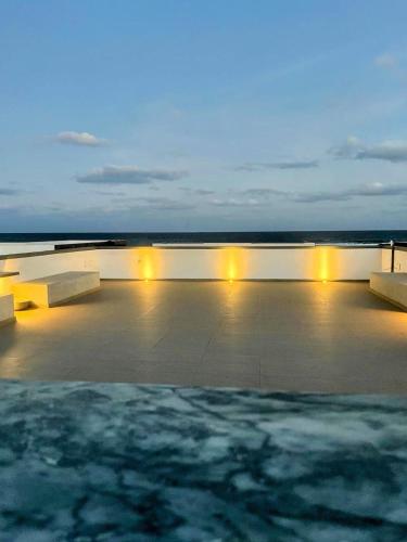 a row of benches sitting on a patio at night at Beach House in Calhau