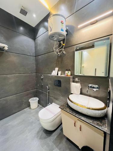 a bathroom with a toilet and a sink and a mirror at Taj Dream A Luxury Hotel - Agra in Agra