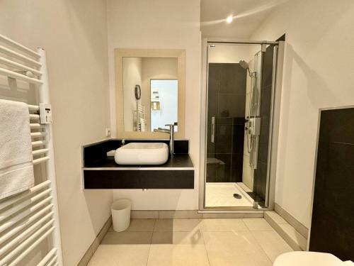 une salle de bain avec une douche, un lavabo et un miroir dans l'établissement Cannes La Croisette - Joli studio au calme coté jardin, à Cannes