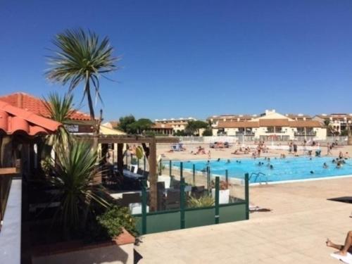 une grande piscine avec des gens dans l'eau dans l'établissement Le Barcarès - Belle vue sur lac - Piscine chauffée, au Barcarès
