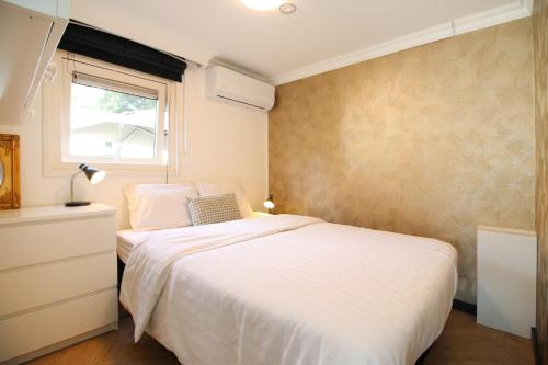 ein Schlafzimmer mit einem weißen Bett und einem Fenster in der Unterkunft KD 808 - Vakantiepark Kijkduin in Kraaijenstein