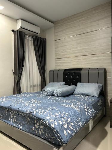 a bed with blue pillows in a bedroom at Livi Guest House in Sekupang