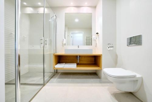 a bathroom with a toilet and a sink and a shower at Centrum Zdrowia i Wypoczynku Ikar in Kołobrzeg