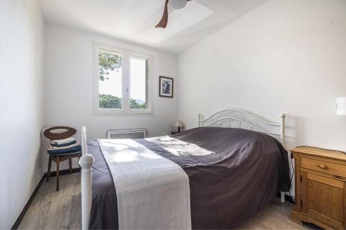 une chambre blanche avec un lit et une fenêtre dans l'établissement L'Alhambra - A 5min à pied de la plage, à Argelès-sur-Mer