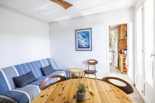 - un salon avec un canapé bleu et une table en bois dans l'établissement L'Alhambra - A 5min à pied de la plage, à Argelès-sur-Mer