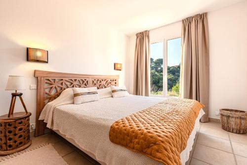 una camera da letto con un letto e una grande finestra di Casa Vinti - Vue mer et montagne climatisé a Porticcio