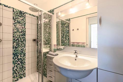 un bagno con lavandino e doccia di Casa Vinti - Vue mer et montagne climatisé a Porticcio