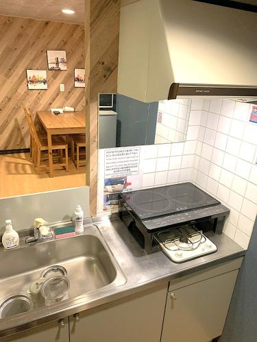 a kitchen counter with a sink and a stove at グランディオーソ中野富士見町 in Tokyo