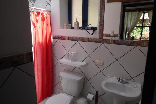 bagno con servizi igienici, lavandino e specchio di Melissa Wasi a Písac