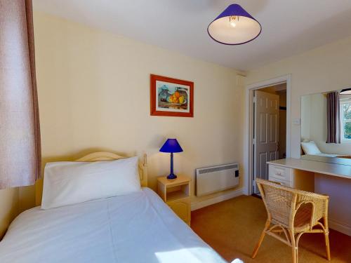 a bedroom with a bed and a desk and a sink at Aughrim Holiday Village No 11 by Trident Holiday Homes in Aughrim