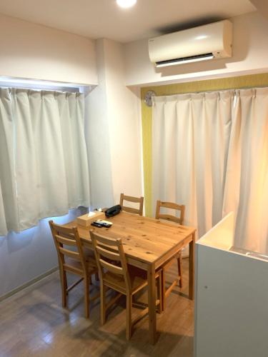 a dining room with a wooden table and chairs at グランディオーソ中野富士見町 in Tokyo