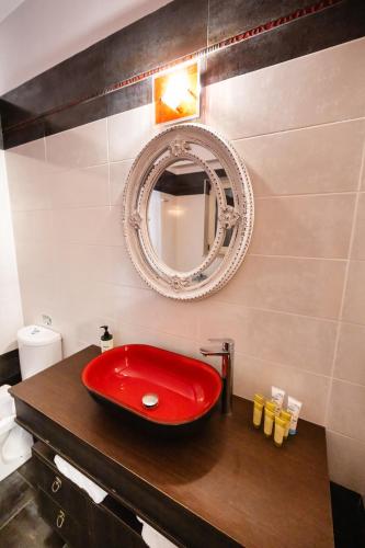 a bathroom with a red sink and a mirror at Villa Galini in Nydri