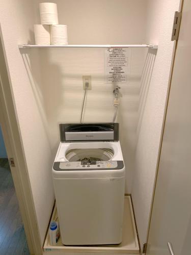 a washer and dryer in a small refrigerator at グランディオーソ中野富士見町 in Tokyo