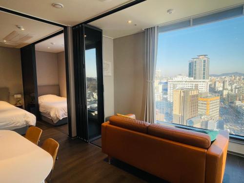 a hotel room with a couch and a large window at Villiv Inn-the City Namsan in Seoul