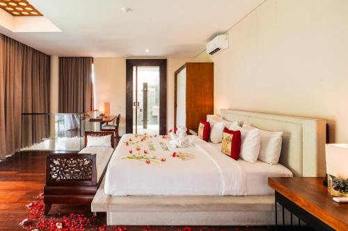 ein Schlafzimmer mit einem großen weißen Bett und einem Schreibtisch in der Unterkunft Javana Royal Villas in Seminyak