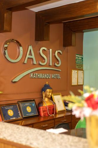 a sign for a katimud hotel with a statue at Oasis Kathmandu Hotel in Kathmandu