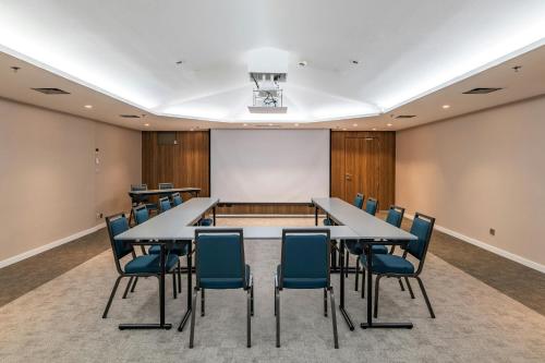 a conference room with tables and chairs and a whiteboard at AC Hotel by Marriott Nice in Nice