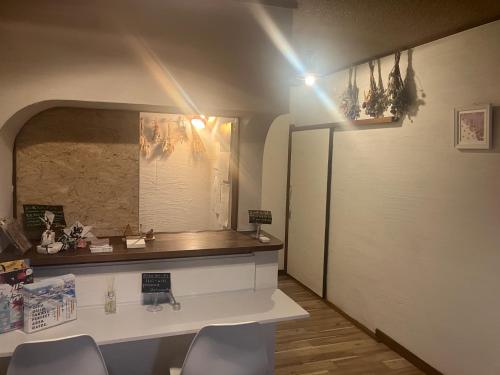 a room with a counter with chairs and a mirror at 交流宿　星降る家　いこい in Gujo