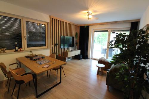 a living room with a table and chairs and a tv at Haus am See in Zeuthen