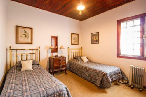 1 dormitorio con 2 camas y ventana en Apartamento Espaçoso Vista Montanha, en Campos do Jordão