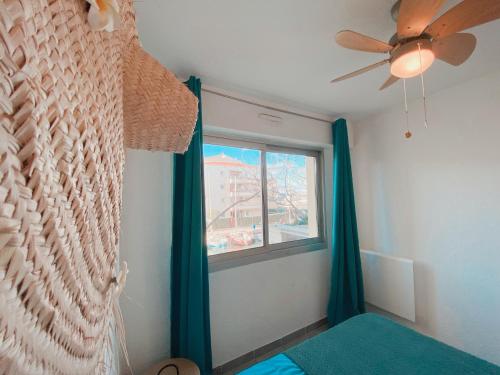 - une chambre avec un ventilateur de plafond et une fenêtre dans l'établissement Superbe T2 au calme avec balcon sur la marina - 10, à Canet