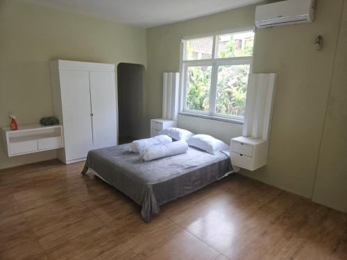 a bedroom with a bed with two pillows and a window at Two Brothers Guesthouse in Legian