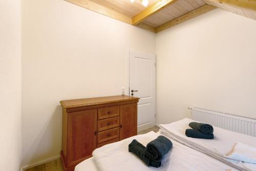 a bedroom with two beds and a wooden dresser at Fewo am Flämingrand in Zahna-Elster