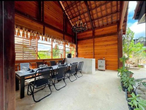 a dining room with a long table and chairs at The Monhi Da Lat City in Xuan An