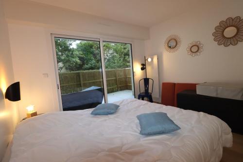 une chambre avec un lit et une grande fenêtre dans l'établissement Le Raspail By Tranquil at Home, Parking - Plage, à La Baule