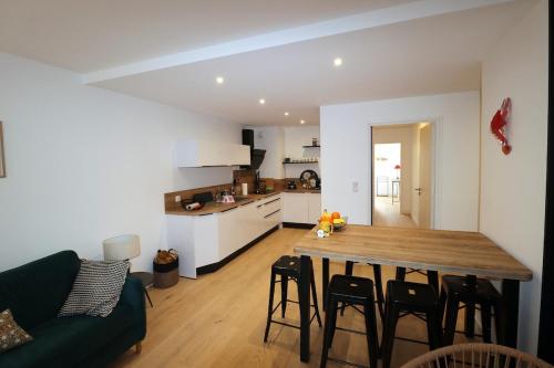 Il comprend un salon et une cuisine avec une table et des chaises en bois. dans l'établissement Le Raspail By Tranquil at Home, Parking - Plage, à La Baule