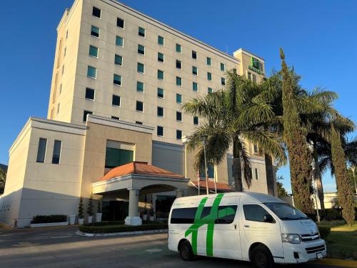a white van parked in front of a building at Holiday Inn Uruapan by IHG in Uruapan del Progreso