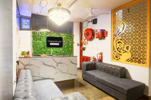 ウダイプールにあるTownhouse Shobhagpura Formerly Fragrance Hotelのソファとテーブルのあるリビングルーム