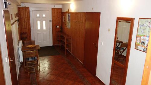 a room with a kitchen with wooden cabinets and a table at Guest House Melusine in Loučná pod Klínovcem