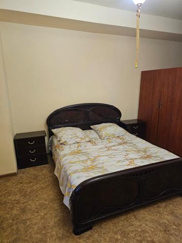 a bed in a room with two nightstands and a bed sidx sidx sidx at Ayg Hotel and Sport Complex Ararat in Davalinskiy Tsemzavod
