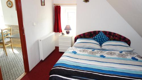 a bedroom with a bed and a table and a window at Guest House Melusine in Loučná pod Klínovcem