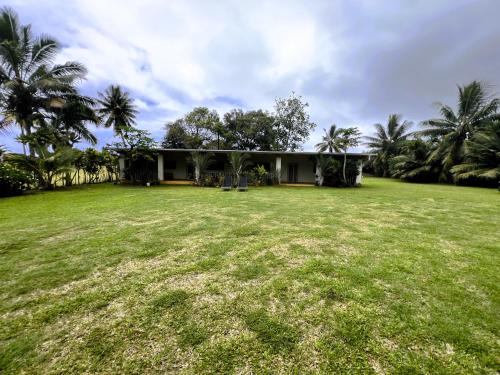 a house with a large yard in front of it at Muri Homeland Villa in Rarotonga