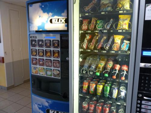 uma máquina de venda automática cheia de latas de refrigerante e garrafas de refrigerante em Hotel Ibis Budget Rennes Cesson em Cesson-Sévigné