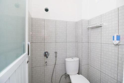 a bathroom with a shower with a toilet in it at RedDoorz Plus Syariah at Polamas Andalas in Padang