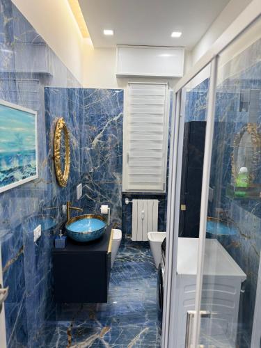 a blue tiled bathroom with a sink and a mirror at Relax assoluto in Cremona