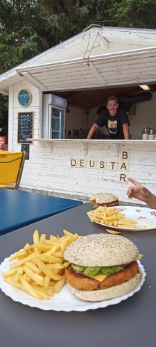 une table avec un hamburger et des frites dans l'établissement Camping de la mer, à PloÃ©ven