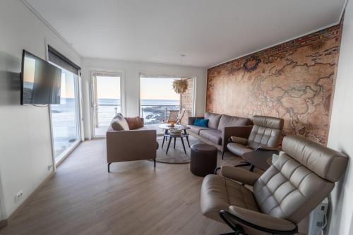 a living room with a couch and chairs and a wall at Runde Panorama - Østen Pilot in Terøy