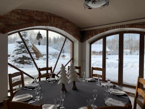 a dining room with a table with snow outside at Jūrvingė in Žadvainai