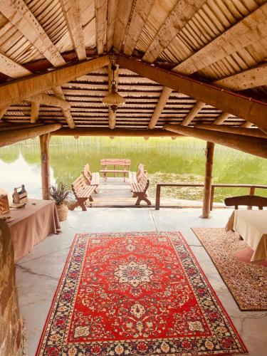 a pavilion with a red rug on a patio at Jūrvingė in Žadvainai